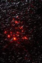 Texture Of Black Coal Stones With Red Rays Of Flame In The Middle.