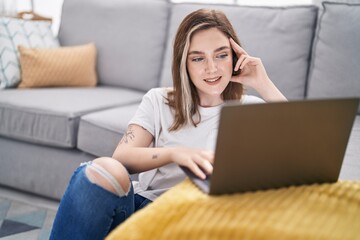 Sticker - Young woman using laptop sitting on floor at home