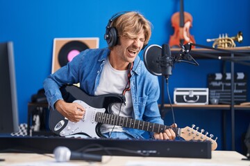 Sticker - Young man artist singing song playing electrical guitar at music studio