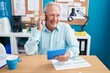 © Krakenimages.com - Middle age grey-haired man business worker talking on smartphone using touchpad at office