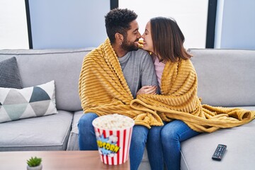 Wall Mural - Man and woman couple watching movie sitting on sofa at home