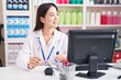 © Krakenimages.com - Young chinese woman pharmacist smiling confident holding glasses at pharmacy