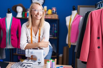 Sticker - Young blonde woman tailor smiling confident leaning on sewing machine at sewing studio