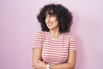 Poster - Young middle east woman standing over pink background smiling looking to the side and staring away thinking.