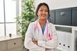 © Krakenimages.com - Young chinese woman wearing doctor uniform standing with arms crossed gesture at clinic