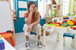 © Krakenimages.com - Young blonde woman teacher sitting on chair with stressed expression at kindergarten