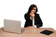 © Asier - Young indian woman in a table with a laptop and tablet isolated pointing with finger at you as if inviting come closer.