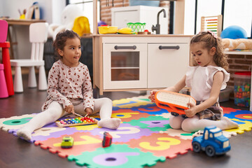 Canvas Print - Two kids playing xylophone sitting on floor at kindergarten