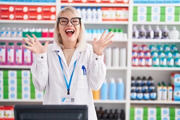 Sticker - Young caucasian woman working at pharmacy drugstore celebrating crazy and amazed for success with arms raised and open eyes screaming excited. winner concept