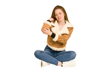 Poster - Young redhead woman sitting on the floor cut out isolated having a shoulder pain.