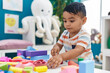 © Krakenimages.com - Adorable hispanic toddler playing with construction blocks standing at kindergarten