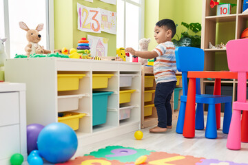 Wall Mural - Adorable hispanic toddler playing at kindergarten