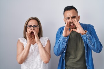 Poster - Hispanic mother and son standing together shouting angry out loud with hands over mouth