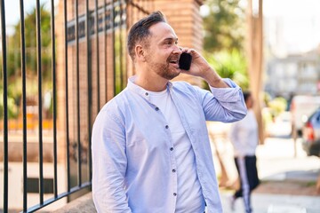 Sticker - Young caucasian man smiling confident talking on the smartphone at street