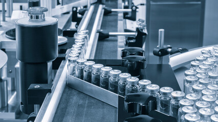 Pharmaceutical industry. Production line machine conveyor with glass bottles ampoules at factory. Pharmaceutical industry concept background.