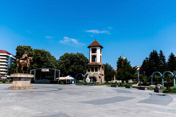 Wall Mural - The old bell tower of  the Ascension Metropolitan cathedral and Michael the Brave statue in the Metropolitan park.Targoviste, Romania.