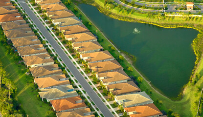 Wall Mural - Aerial view of tightly packed homes in Florida closed living clubs with lake water in the middle. Family houses as example of real estate development in american suburbs