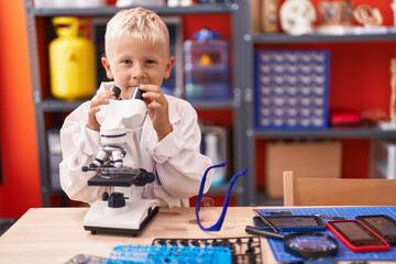 Poster - Adorable toddler student using microscope standing at classroom