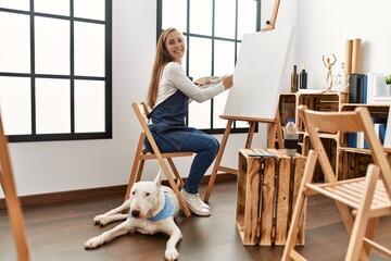 Poster - Young caucasian woman smiling confident drawing with dog at art studio