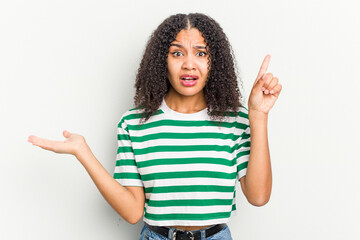 Young african american woman isolated on white background holding and showing a product on hand.