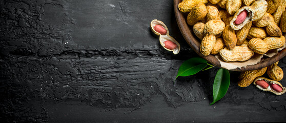 Canvas Print - Peanuts in a bowl with leaves .