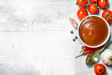 Canvas Print - Tomato sauce in bowl with spoon, garlic and cherry.