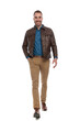 © Viorel Sima - happy casual guy in denim shirt with leather jacket walking with hand in pocket