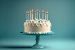 © abdulmoizjaangda - White birthday cake with candles over blue background, blank empty space