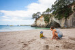 © Cavan Images - Mother and child playing on beach, Hahei, Coromandel, New Zealand