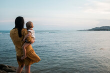 Woman And Baby Looking Out Over The Ocean On Koh Samui Thailand