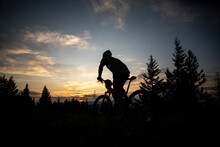 A Mountain Biker Rides Towards The Sunset On  Top OfBlue Mountain