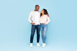 © Prostock-studio - Full length shot portrait of black couple hugging and looking at each other, posing on blue background, full body length