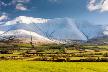 Canvas Print - Snow on the Galty mountains with green fields in Ireland