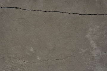 Wall Mural - A cracked concrete wall covered with a gray cement texture as a background. Horizontal design with copy space. High quality photo