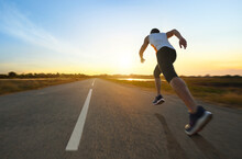 Action Motion Blur Of A Man Running On Country Road With Sunrise Background...