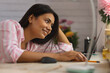 © IndiaPix - Close-up portrait of a young woman leaning on desk and using laptop