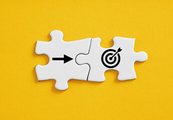 Wall Mural - goal target and arrow symbols connected on jigsaw puzzle pieces.