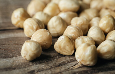 Wall Mural - Heap of roasted hazelnuts close-up on a wooden background.