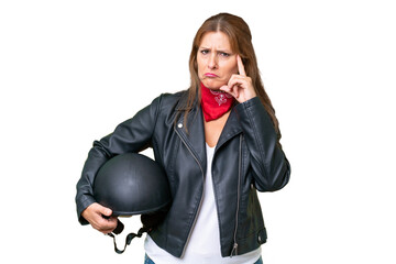 Wall Mural - Middle-aged caucasian woman with a motorcycle helmet over isolated background thinking an idea