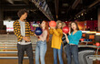 © Westend61 - Happy man with women with balls enjoying at bowling alley