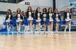 © PoppyPix - Full shot of cheerleaders walking toward the camera with ble pom-poms in their hands. Sport concept. High quality photo
