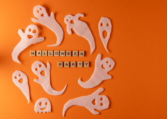 Wall Mural - White ghosts craft for Halloween party. Wrapping paper ghost on orange background top view. Cartoon creepy Whisper. DIY hand made. Set boo characters. Word wooden letter phrase.