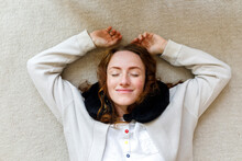 Smiling Woman With Eyes Closed Lying On Floor At Home