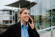 © Drobot Dean - Young business woman tallking on cellphone while standing at the city street