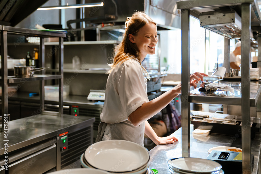 kitchen receipts, orders, bills : support centre... Young woman holding order receipts while working in restaurant kitchen ...