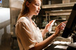 © Drobot Dean - Young woman holding order receipts while working in restaurant kitchen