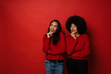 Wall Mural - Two young african american women smiling and looking aside at copyspace