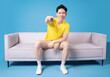 © Timeimage - Image of young Asian man sitting on sofa
