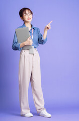 Wall Mural - Photo of young Asian businesswoman holding laptop on background