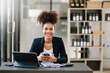© Nuttapong punna - Young attractive Africa female office worker business suits smiling at camera in office .
